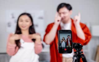 Couple recording dance video on smartphone.